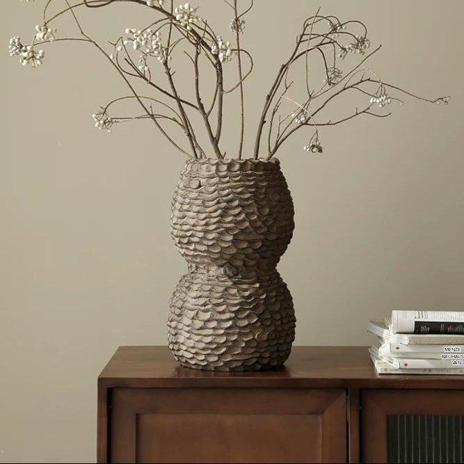 A textured, dark grey handmade ceramic vase with a tapered neck and minimalist design.
