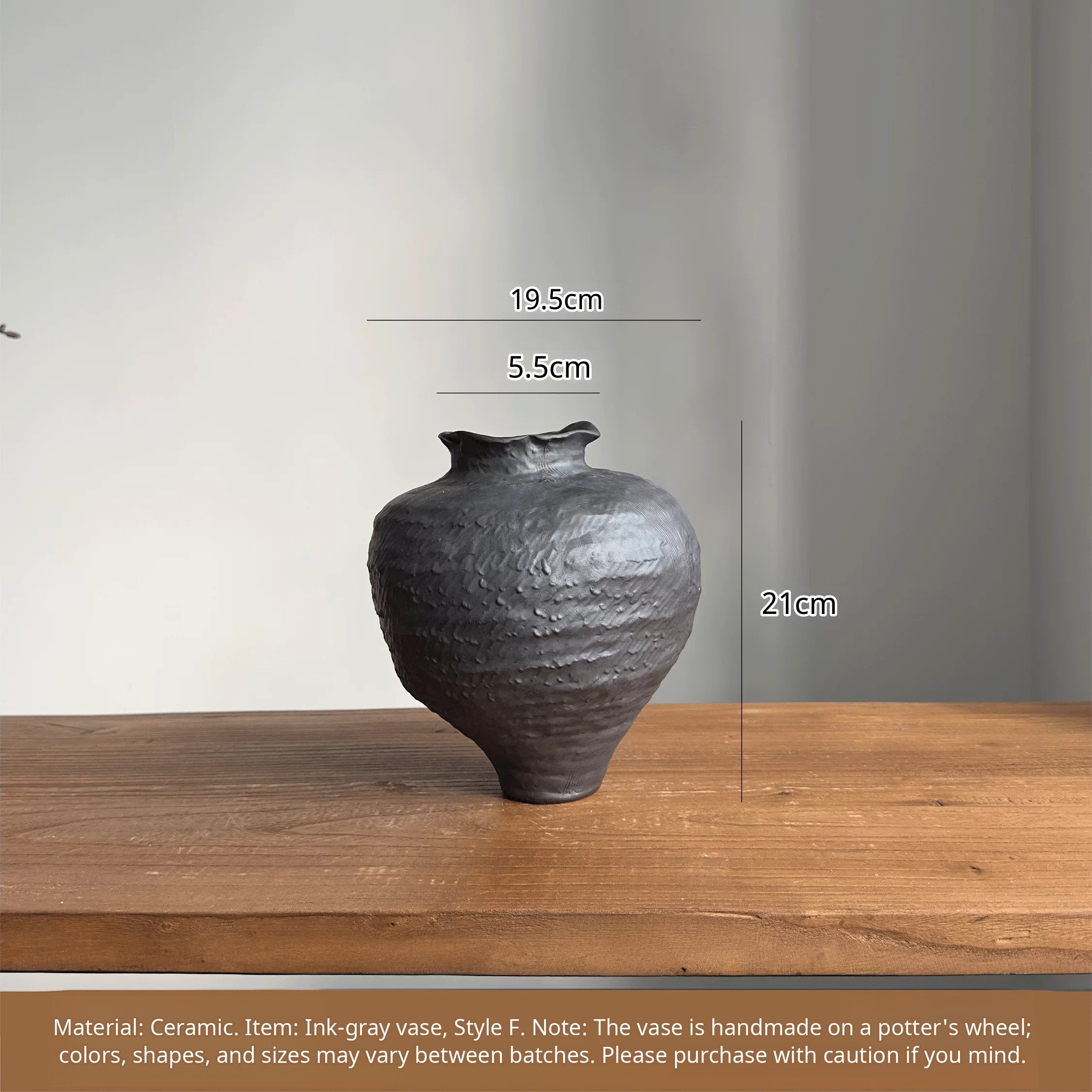 A handmade black ceramic vase with a textured clay finish and an artistic sculptural design.