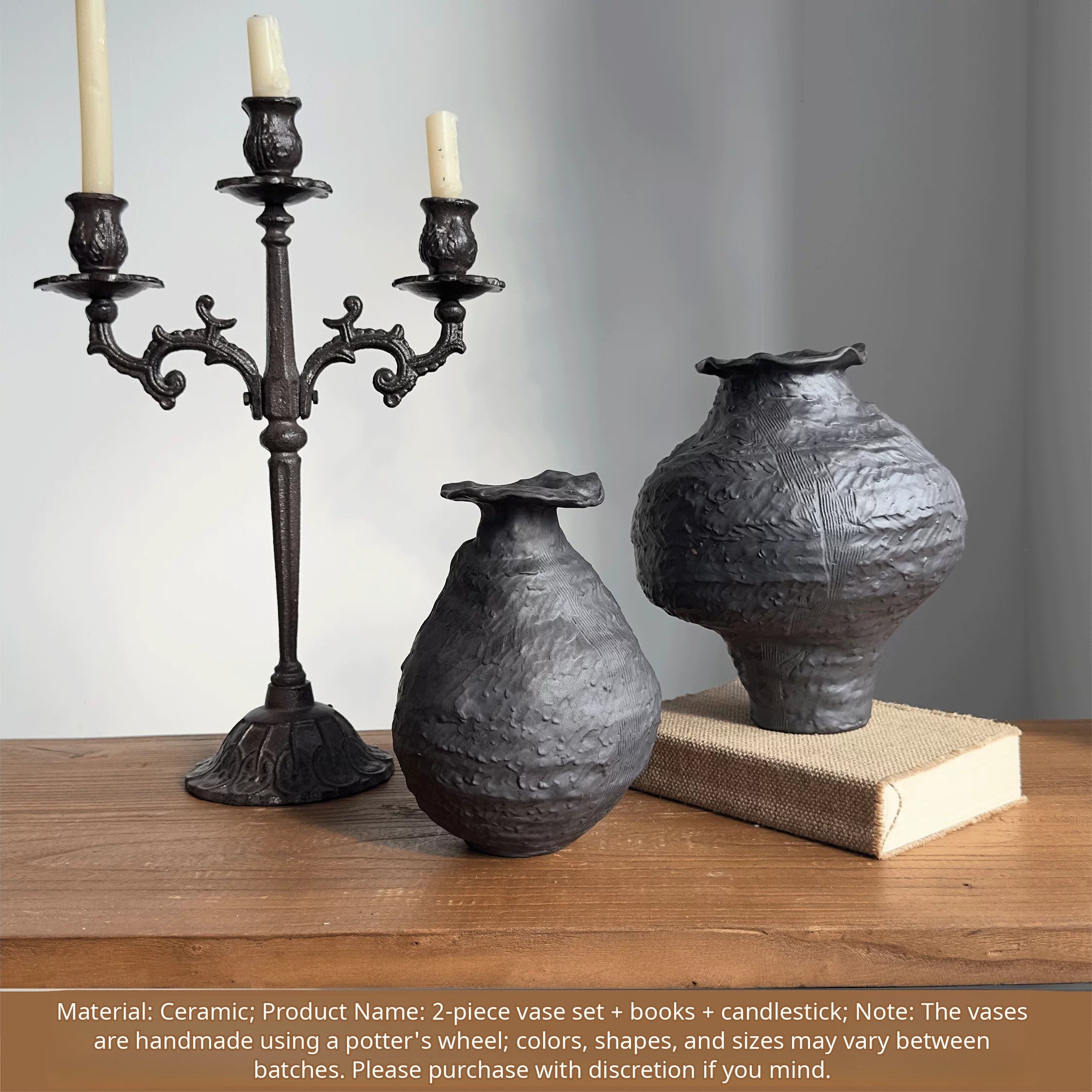 A handmade black ceramic vase with a textured clay finish and an artistic sculptural design.
