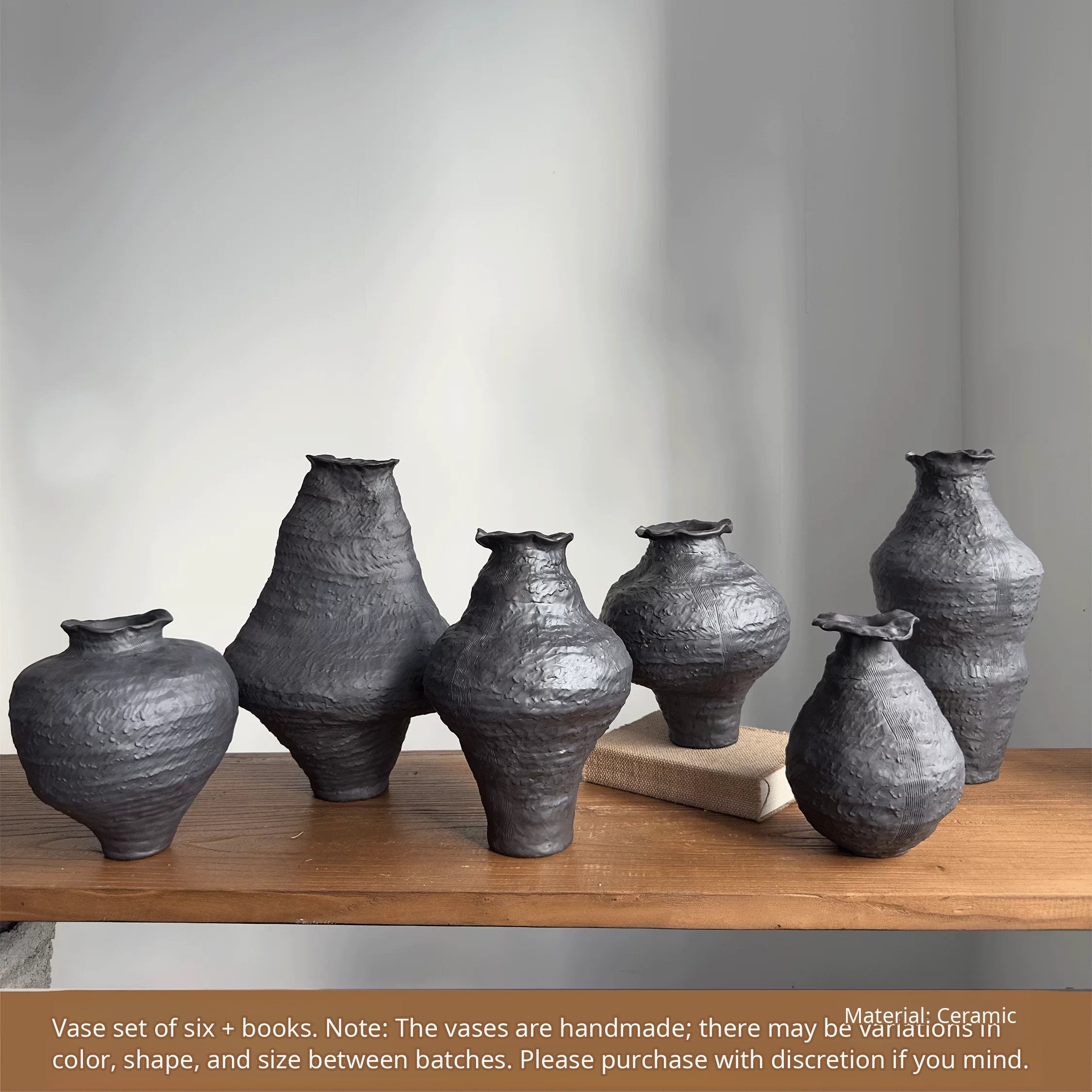 Handmade black ceramic vase with a textured clay finish and a sculptural, artistic design.