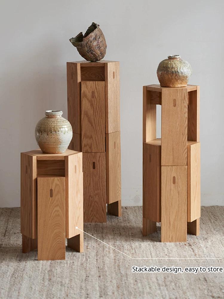 A minimalist solid wood stackable stool with a geometric design, shown as a natural wood side table.