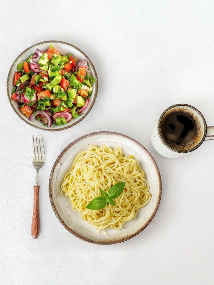 White glazed ceramic dinnerware set featuring pasta, salad & coffee.