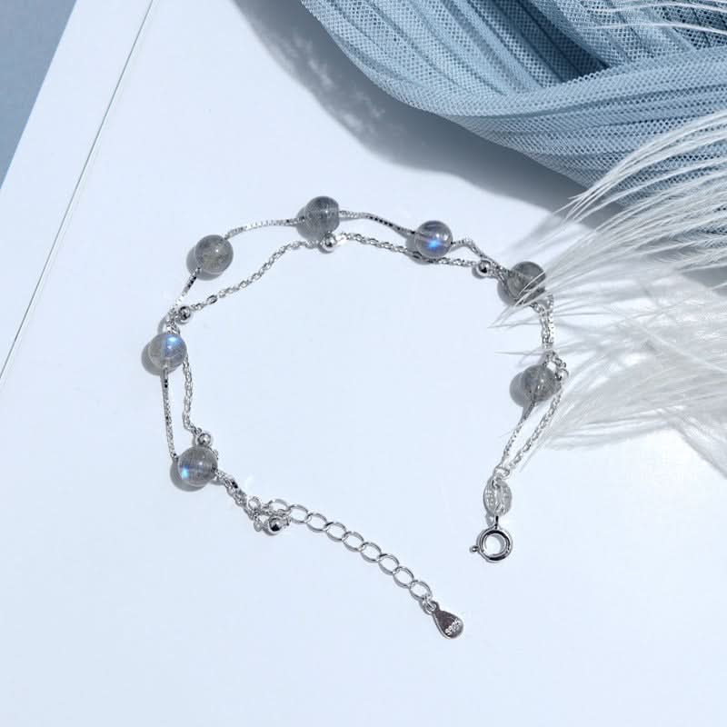 Moonstone bracelet with S925 silver chain, featuring round iridescent beads and adjustable clasp.