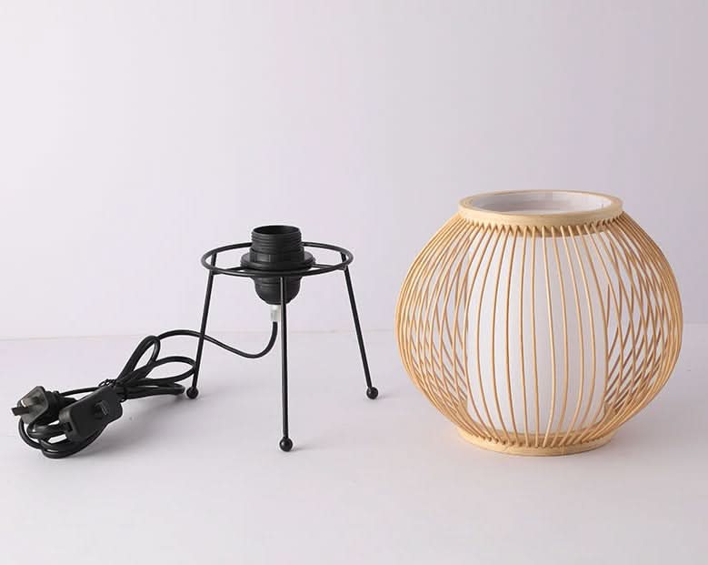 Natural rattan table lamp with white diffuser and black metal lamp holder. Home decor.
