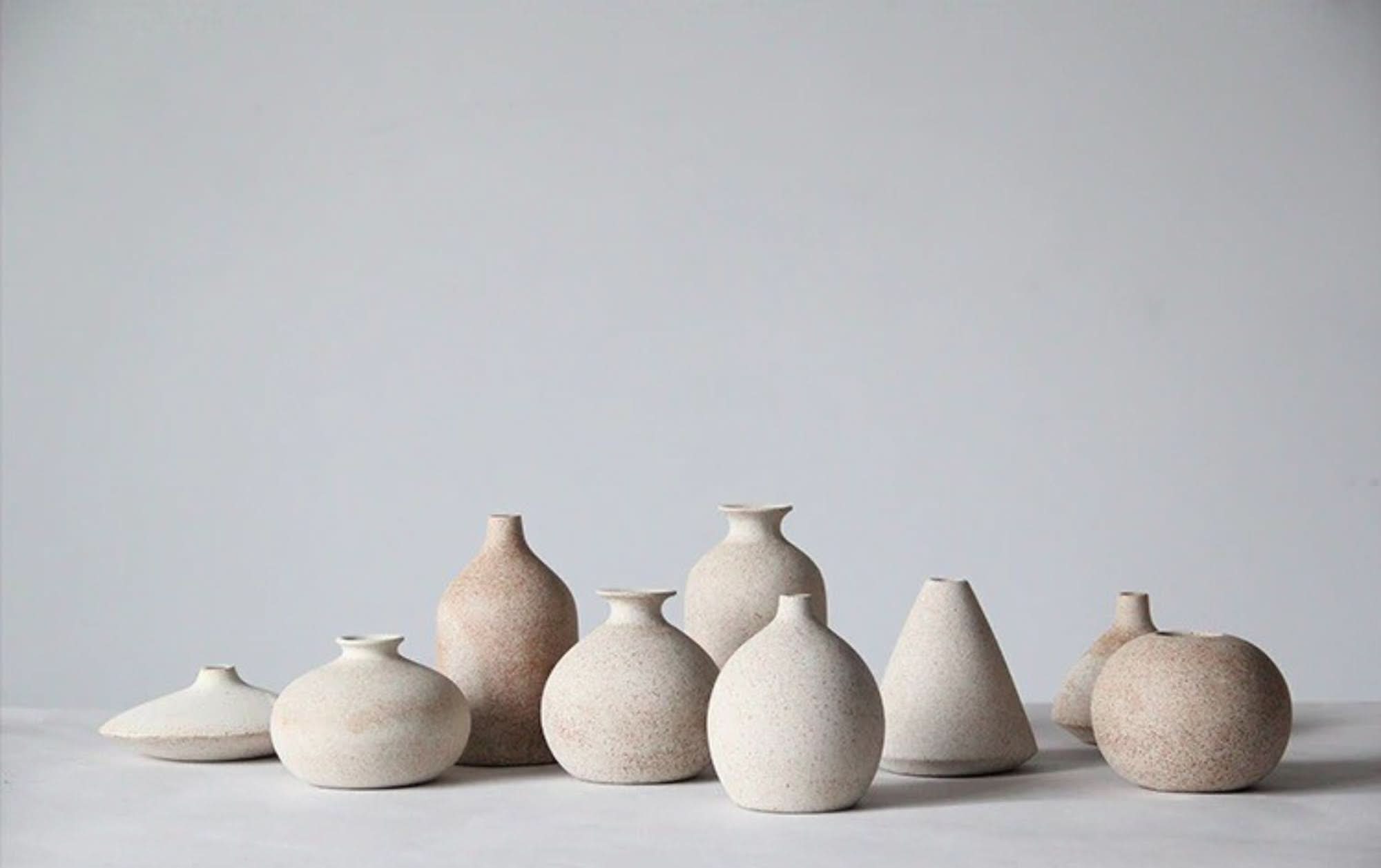 2x1 Ceramic Small Cream Vases: Assorted textured ceramic vases in cream and speckled tan on a white surface.