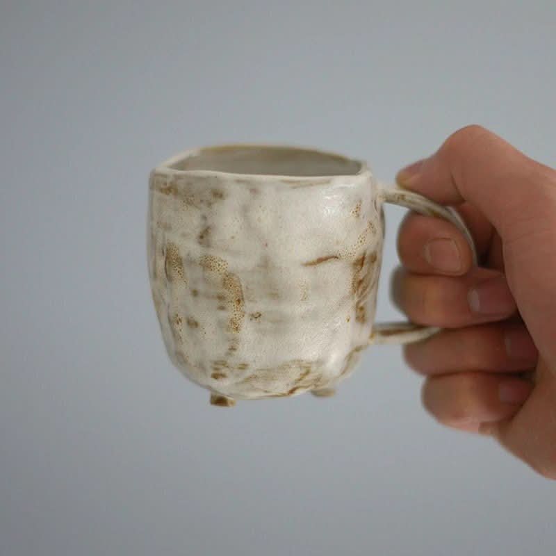 Textured off-white stoneware mug with brown speckles, part of a 2X1 Stoneware Mug Set.