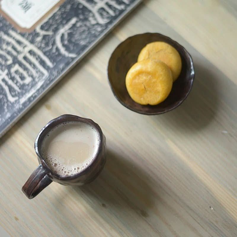 Dark brown 2X1 Stoneware Mug Set filled with coffee, next to cookies in a bowl on a wooden table.