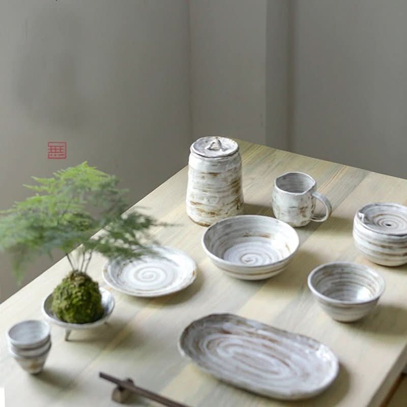 2X1 Stoneware Mug Set and matching ceramic tableware with spiral design on wooden table.