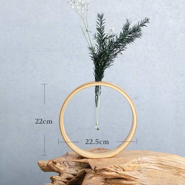 Wooden ring wall flower vase with greenery, on rustic wood.