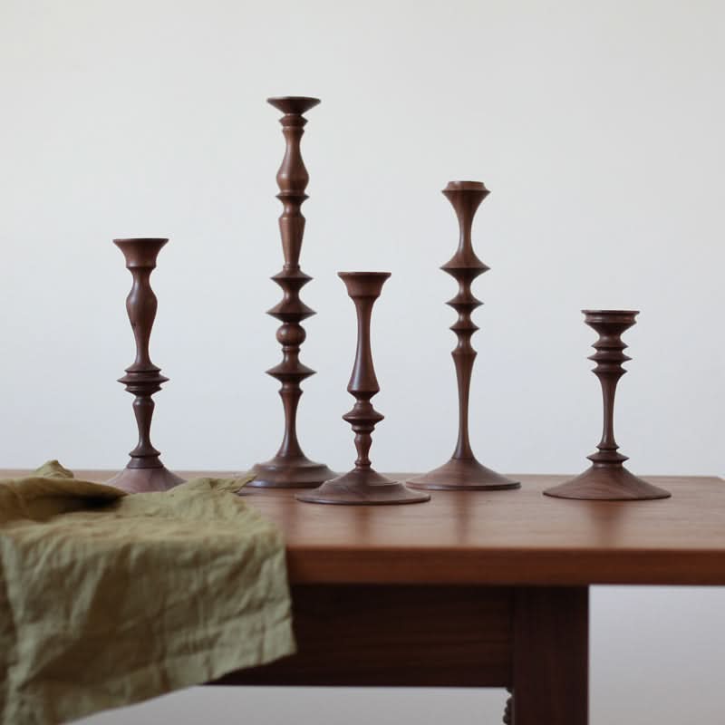 Set of 5 Wood Pillar Candle Holders Made of Walnut on a wooden table with green cloth.