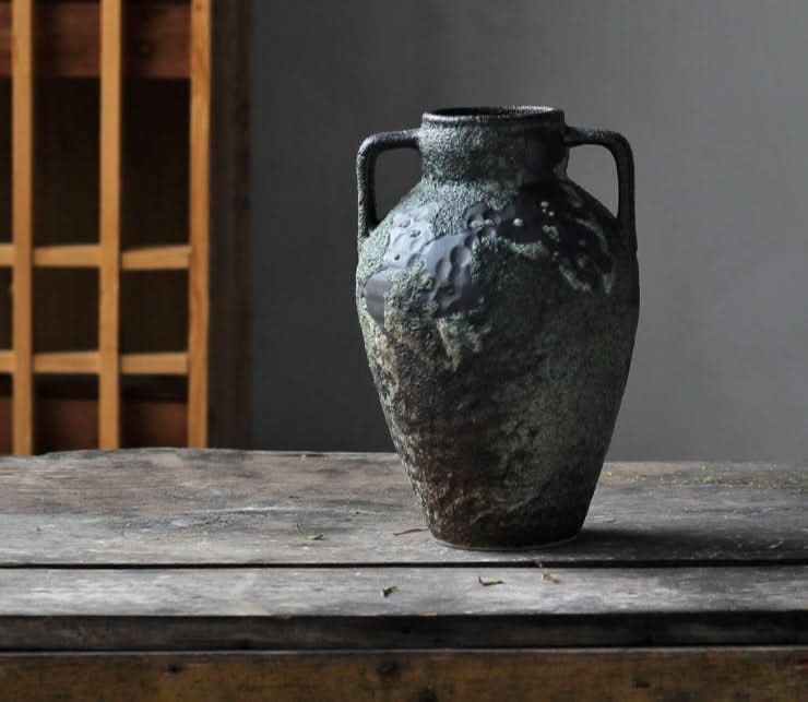 Rustic Wabi-sabi small ceramic vase in textured green and black on wooden table.