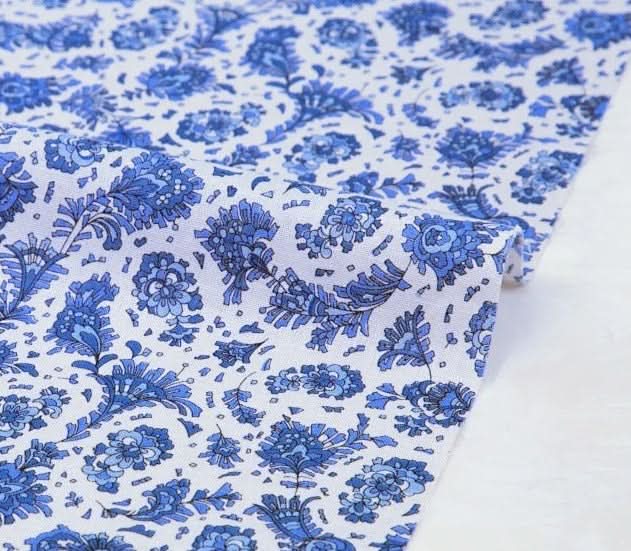 Floral muslin fabric, blue flowers on white.