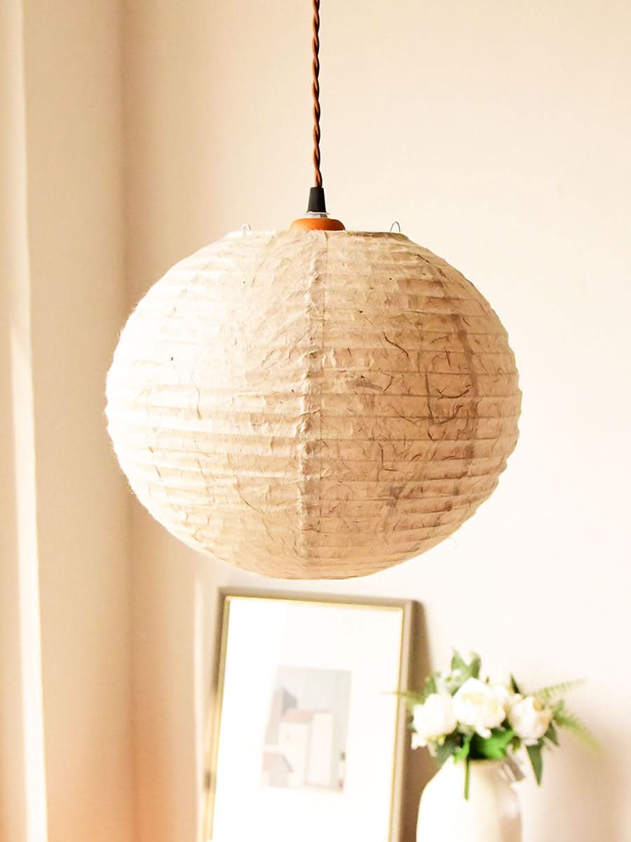 Natural textured Handmade Paper Lampshade with a warm glow, hanging in a styled home decor setting.