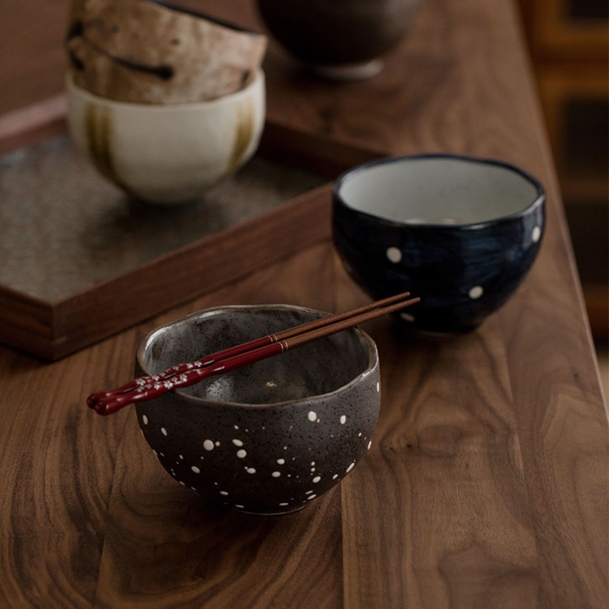 Dark speckle bowl with white dots and red floral chopsticks, part of Japanese Tea Set.