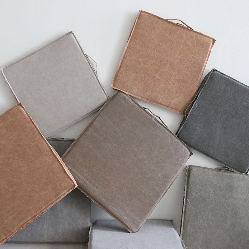 Customizable distressed linen square cushion in muted earth tones, removable & washable.