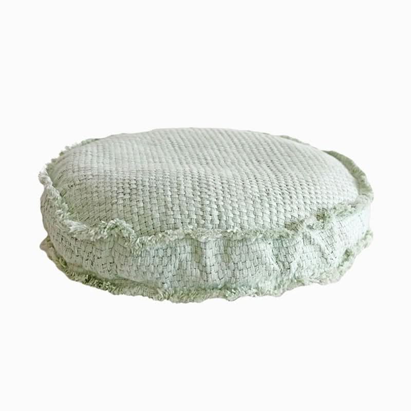 Light green textured washable floor cushion with frayed edges.