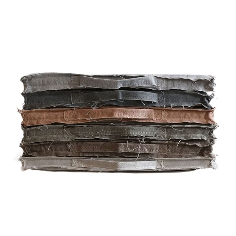 Stack of customizable distressed linen cushions in muted colors, removable and washable.