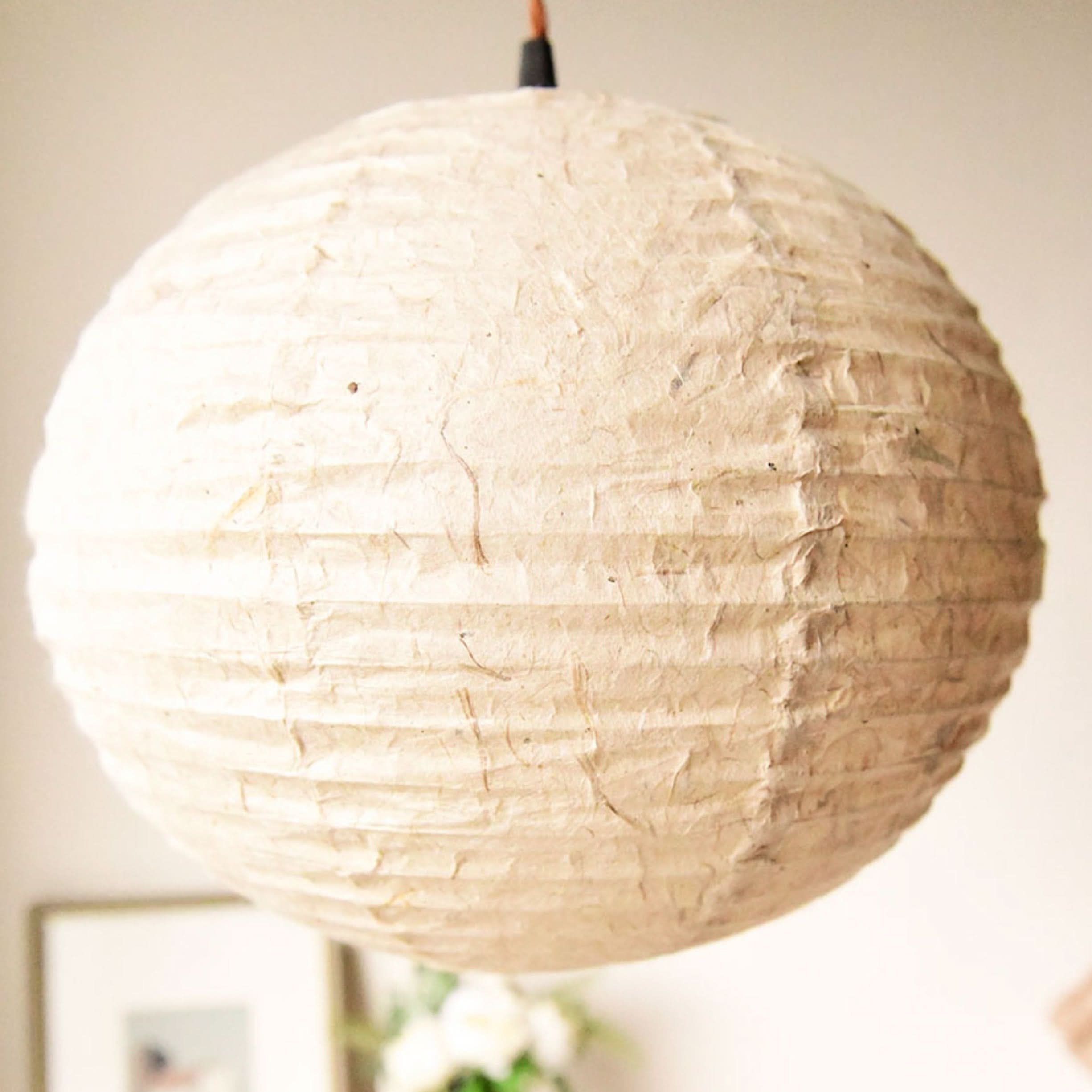 Textured beige handmade paper lampshade, natural material, hanging light fixture.