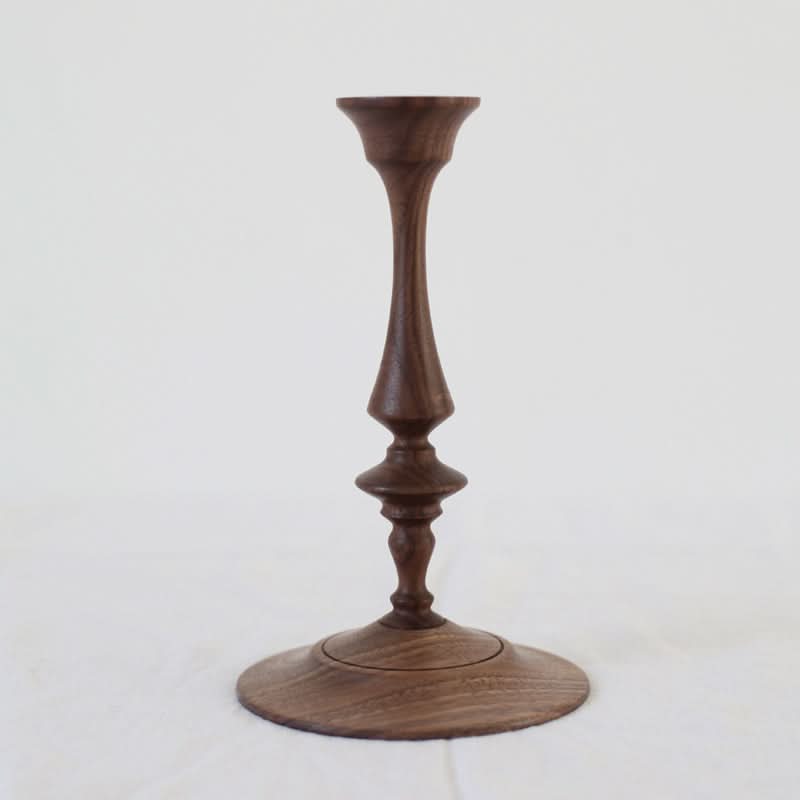 Elegant walnut wood pillar candle holder with a turned spindle design on a white background.
