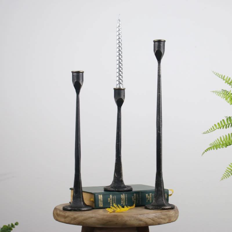 Black iron candle holders on books, home decor essential.