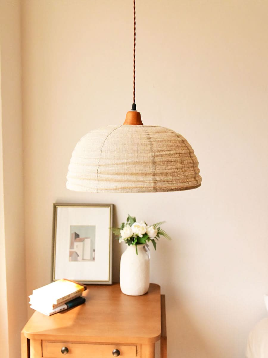 Dome Lamp Shade with Hemp Fabric, natural beige textured material, hangs above a bedside table.