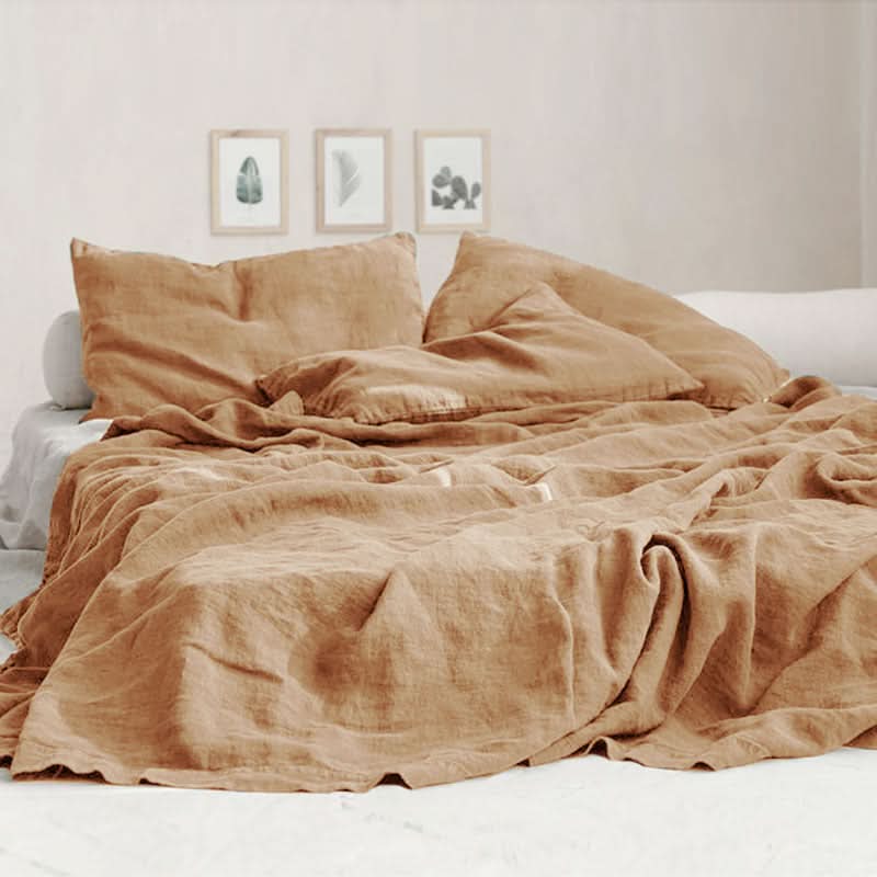 Caramel linen bed sheets with natural texture on a bed with decorative artwork.