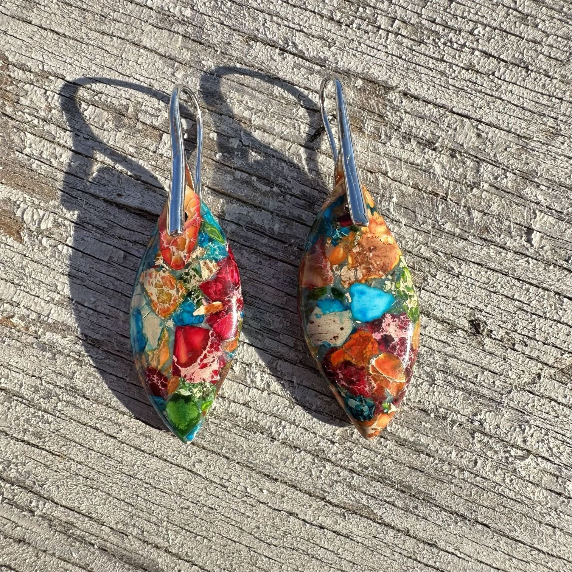 Multi-colored natural stone earrings with silver hooks, showcasing vibrant reds, blues, and oranges.