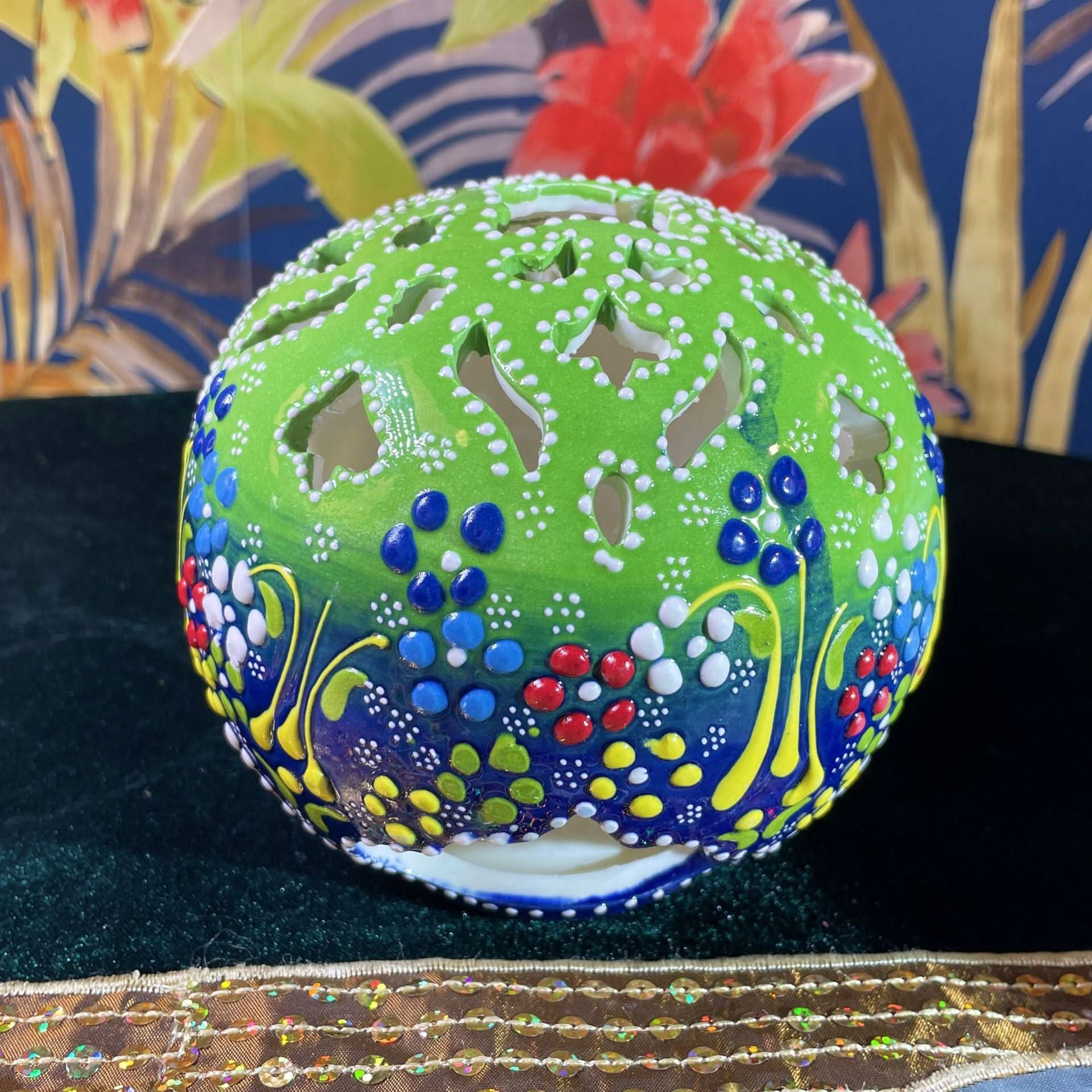 Green Turkish ceramic hand-painted candle with floral patterns on velvet.