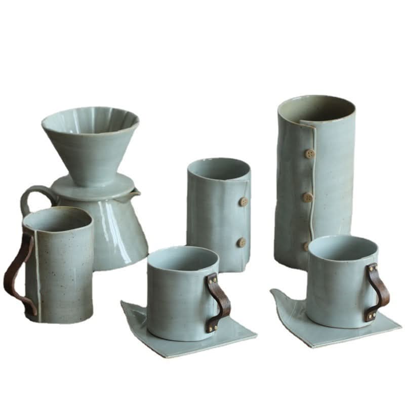 Grey textile folded style ceramic cups set with coffee brewer.