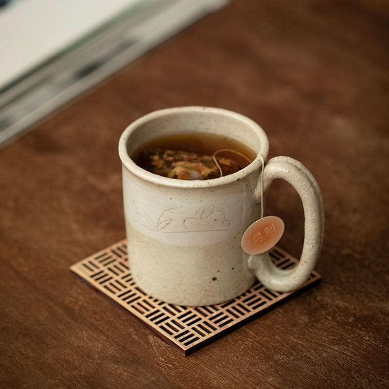 Stoneware Wangu Burning Rabbit Mug Made In Japan on wooden coaster, filled with tea.
