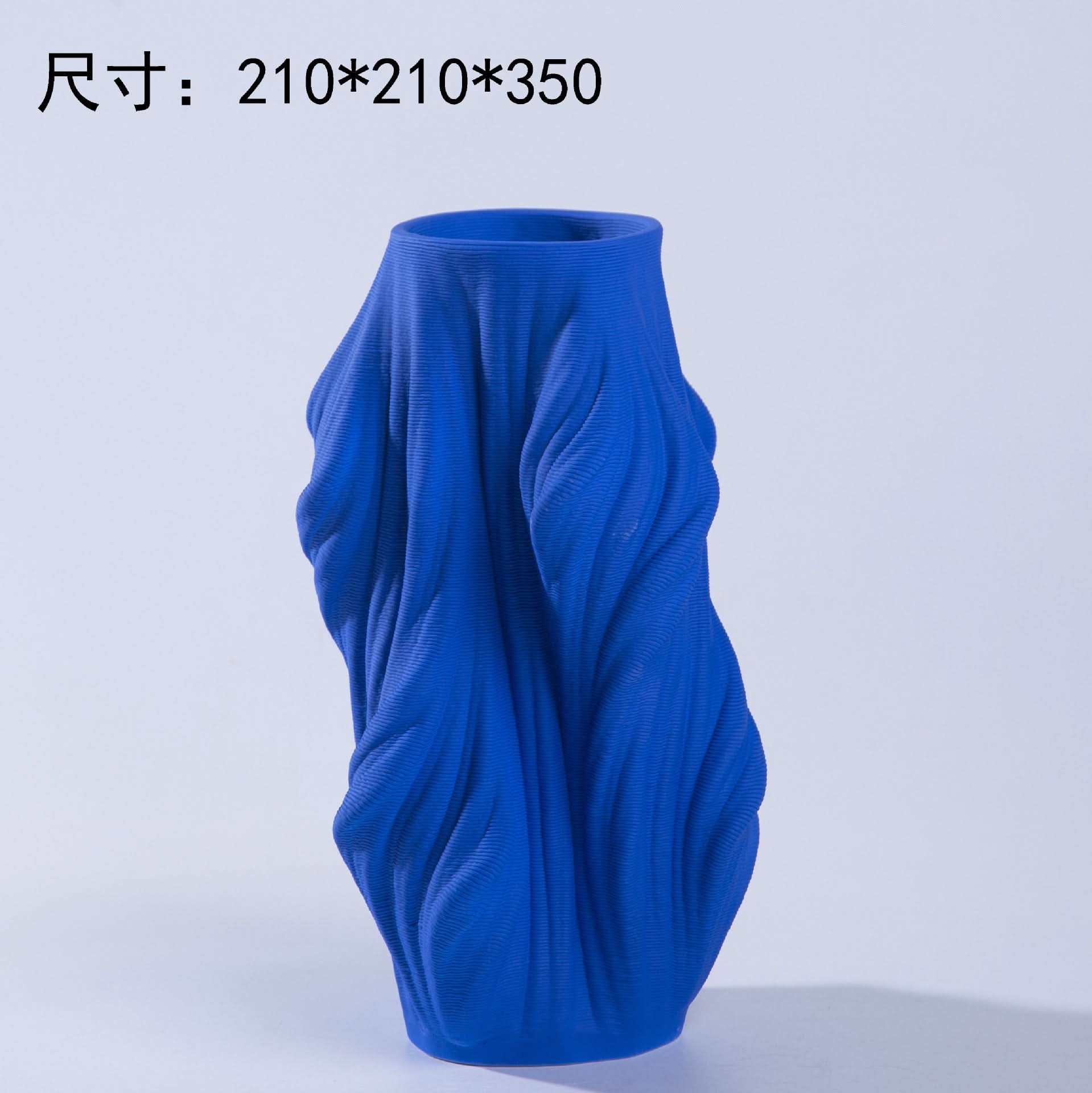 Vibrant blue 3D printed ceramic vase with a textured, flowing design on a light background.