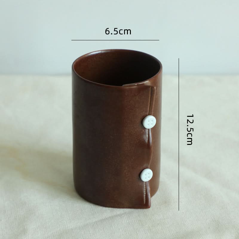 Brown textile folded style ceramic cup with white button accents, part of a coffee mug set.