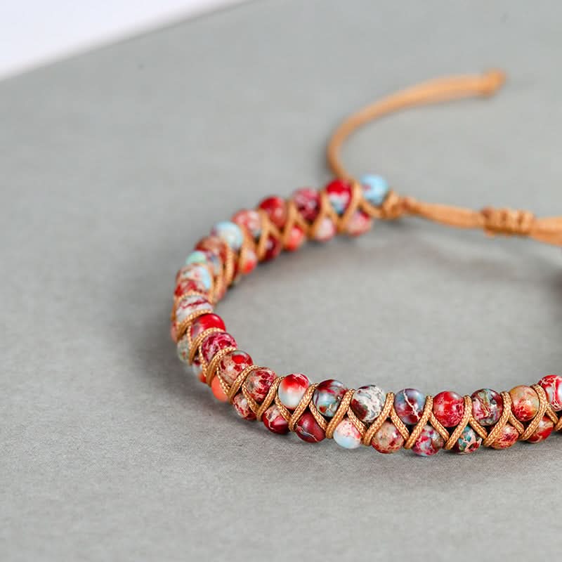 Emperor stone bracelet 4mm beads with natural red, white & blue hues, macrame woven on gray backdrop.