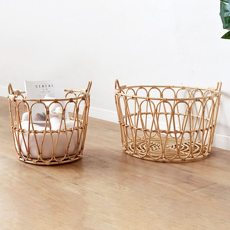 Natural rattan round storage basket with zig zag pattern on wood floor, one filled with towels and a magazine.