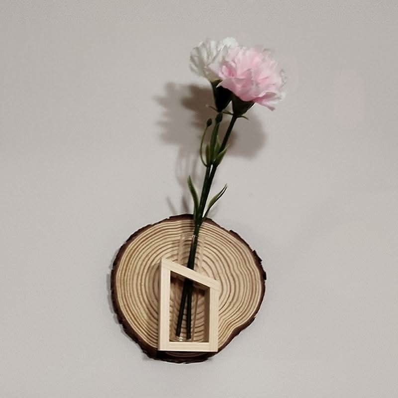 Wall Plant Hanger Tree Ring: rustic wood slice with glass vase holding pink and white flowers.