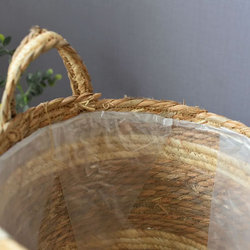 Natural woven plant basket with handles, lined with clear plastic, home decor essential.
