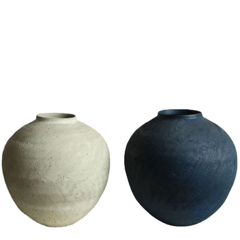 Two textured wabi-sabi vases, one cream and one dark blue, showcasing artisanal home decor.