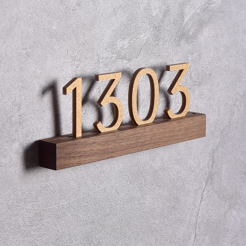 Walnut Beech solid wood custom door plate with gold numbers "1303" on a textured grey wall.