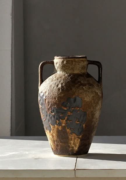 Rustic brown ceramic vase with textured finish and handles, ideal home decor.