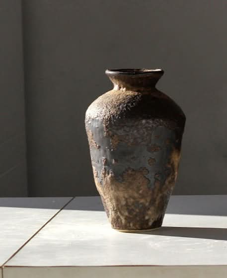 Textured dark brown and tan ceramic vase, a home decor piece.