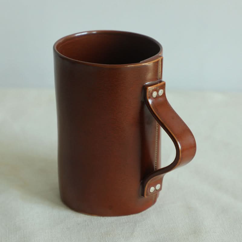 Brown ceramic cup with folded textile handle from the Ceramic Cups Textile Folded Style Brown Set.