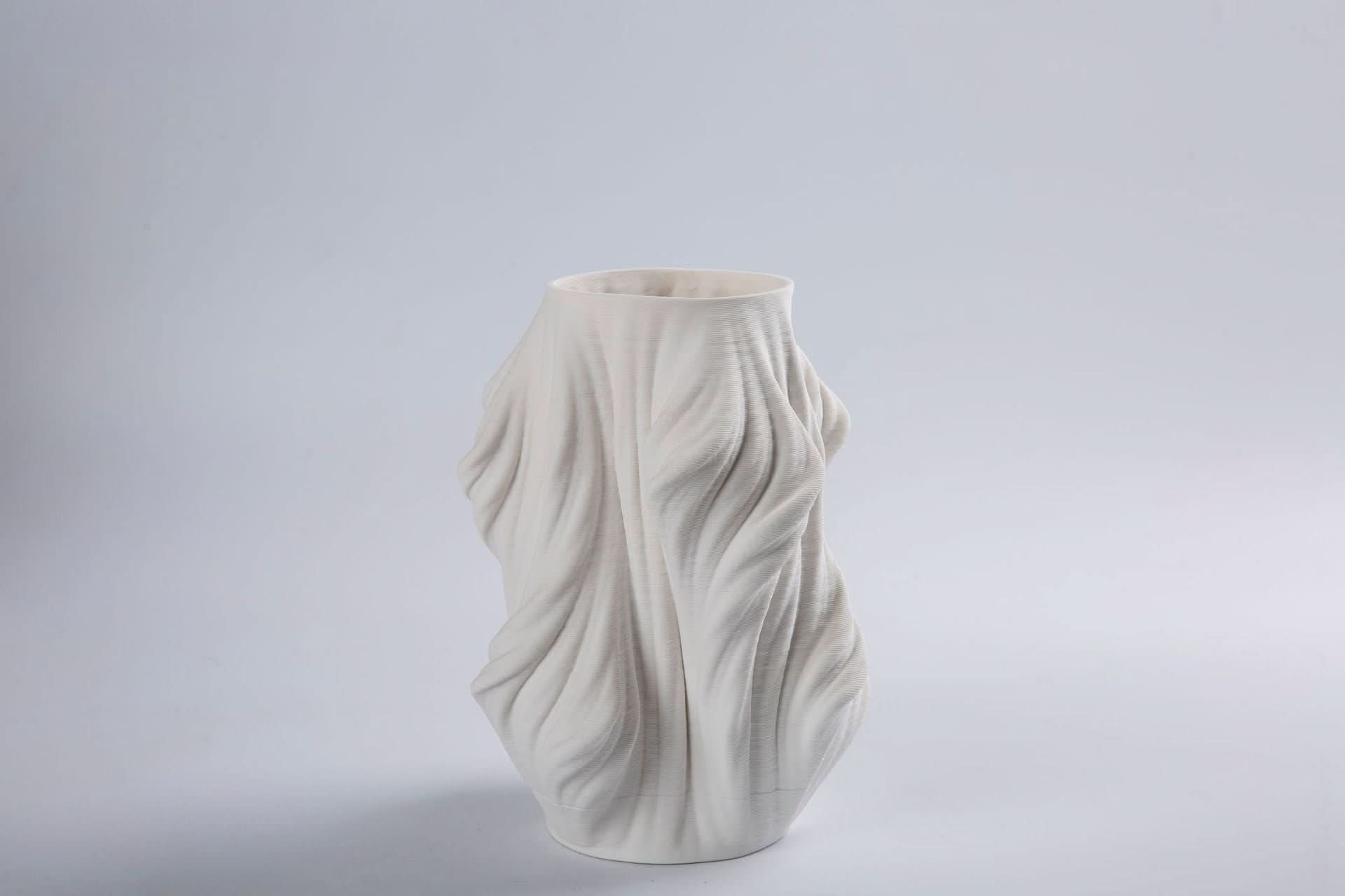 White 3D Printed Vase Made of Ceramic with flowing, textured design on a light gray background.