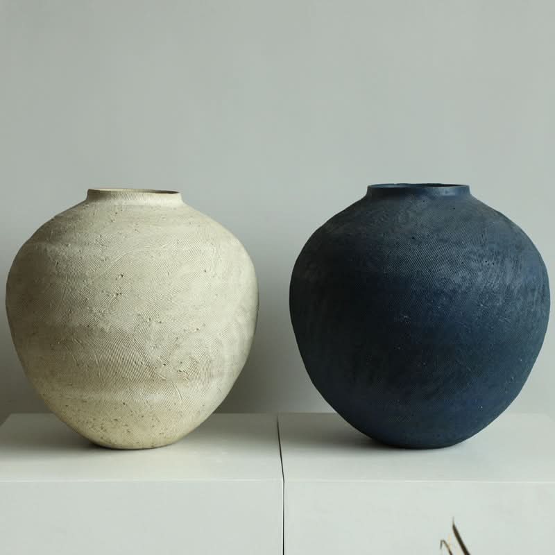 Two round textured Wabi-Sabi vases: one cream, one navy. Home decor.