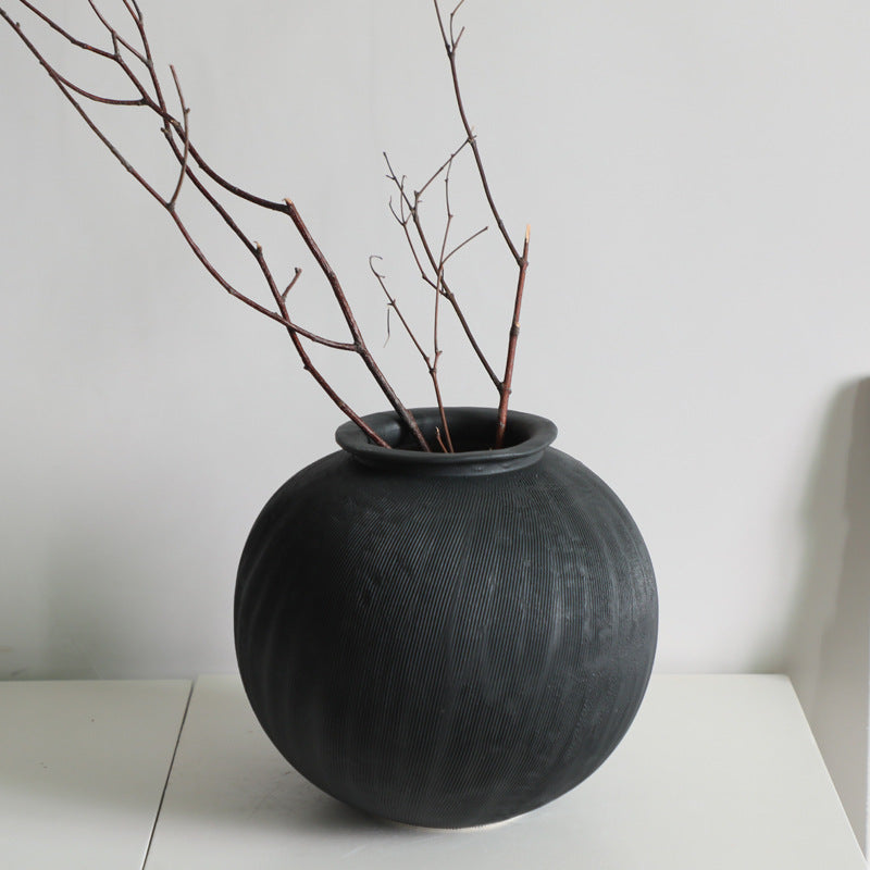 Black textured ceramic vase, round shape.