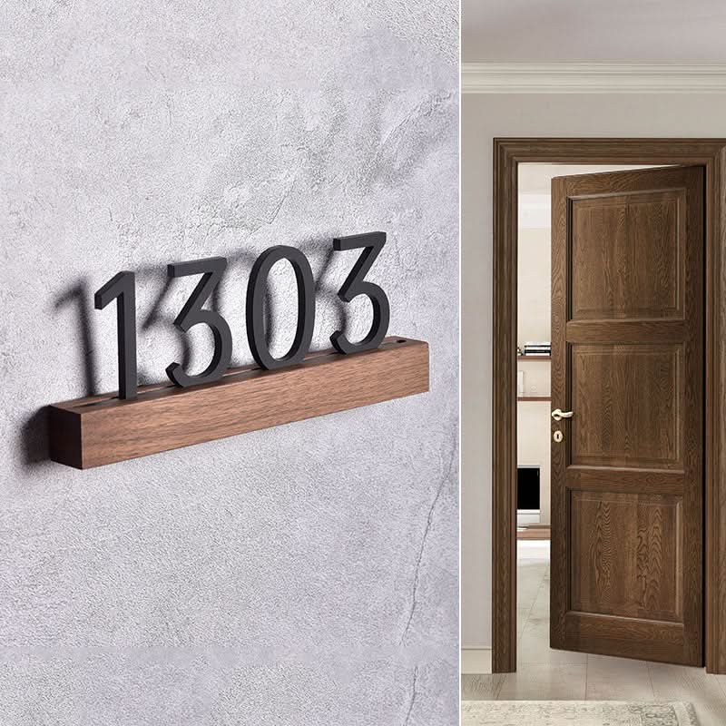 Solid wood custom door plate with numbers 1303 on a textured gray wall, next to a wooden door.