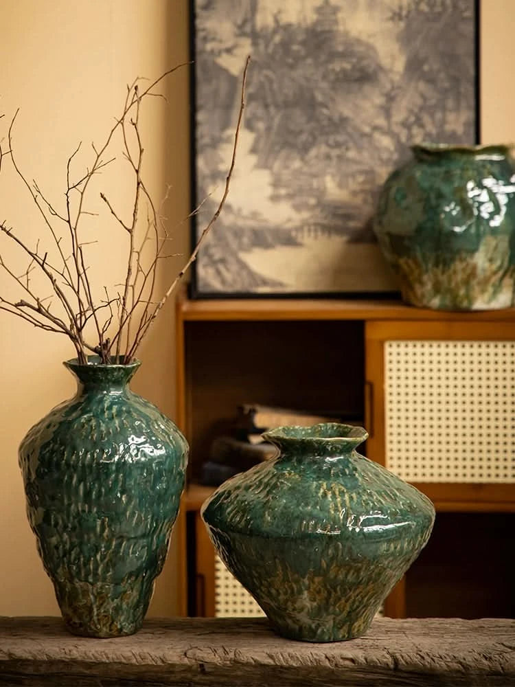 Wabi-sabi distressed rustic vases with dark green glaze, natural home decor on wood shelf.
