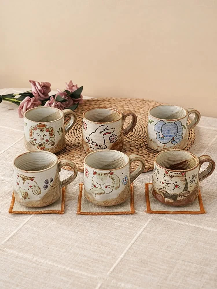 Hand painted coffee mug 11oz with animal designs, neutral earth tones, ceramic, on coasters.