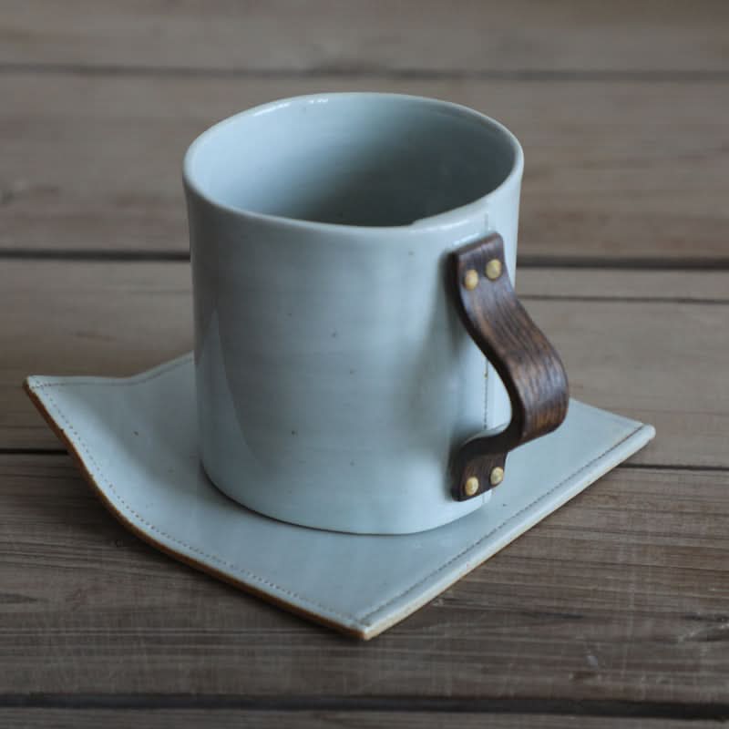 Grey ceramic cup with textile folded style handle on matching saucer, part of the Coffee Mug Set.