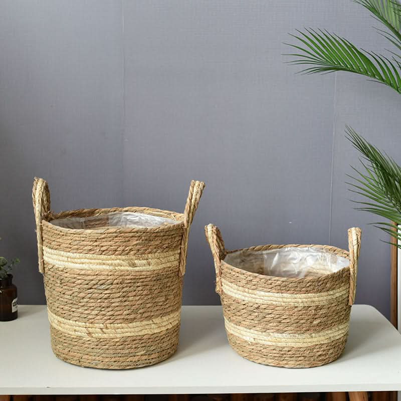 Natural jute plant basket with woven handles and stripes, perfect for home decor.