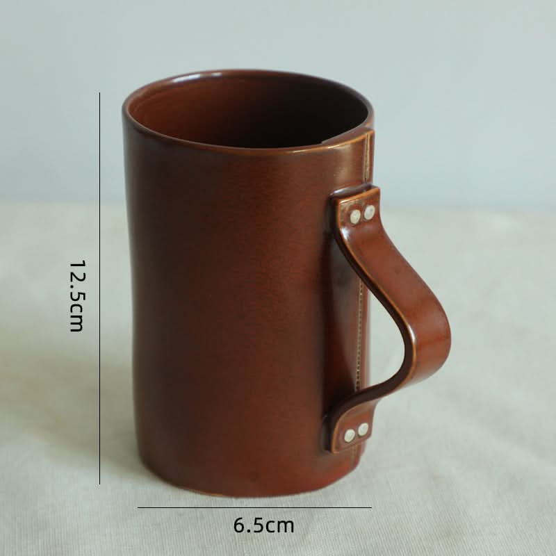Brown ceramic coffee mug with textile folded style handle.